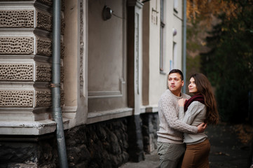 Young couple wearing on tied warm sweaters hugging in love under
