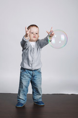 little funny boy plays with bubbles