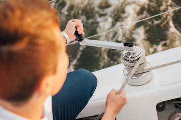 Man on a yacht holding rope