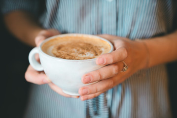 girl holding  cup of coffee close-up