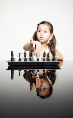 Adorable little girl playing real chess in competition