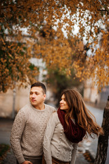 Fototapeta premium Young couple wearing on tied warm sweaters hugging in love at ci