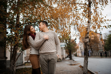 Young couple wearing on tied warm sweaters hugging in love at ci