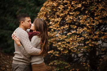 Fototapeta premium Young couple wearing on tied warm sweaters hugging in love at ci