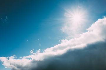 Obraz na płótnie Canvas Dramatic Sky, Blue And White Colors. Sun Shine Over Fluffy Cloud