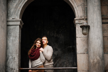 Young couple wearing on tied warm sweaters hugging in love at ol