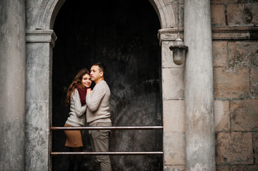 Young couple wearing on tied warm sweaters hugging in love at ol