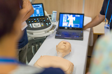 Team of medical doctor students learning to do advanced medical examination of patient with ultra sound scanner machine on ultrasound techniques workshop.