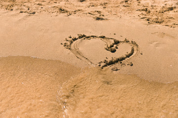 Heart drawn on the sand at the beach. Figure heart for you.