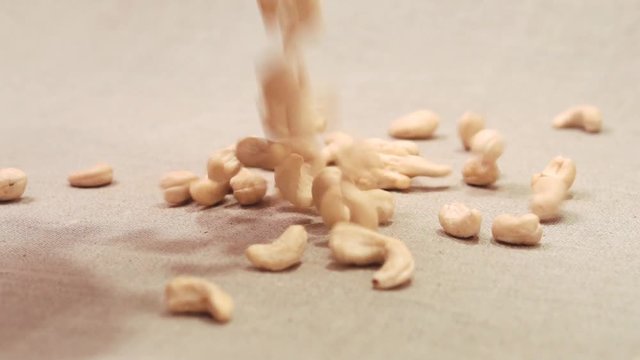 Cashews nuts falling down on a linen fabric