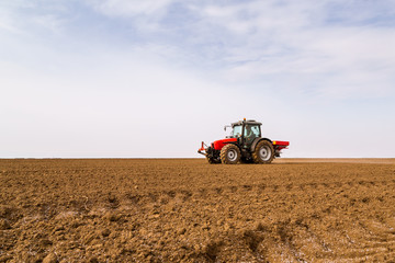 Farmer fertilizing arable land with nitrogen, phosphorus, potassium fertilizer