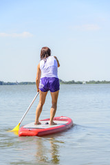 auf dem Board stehend über den See paddeln