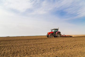 Farmer in tractor preparing land with seedbed cultivator