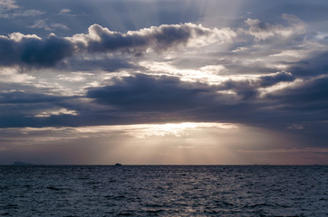 The sun's rays passing through the storm clouds over the sea