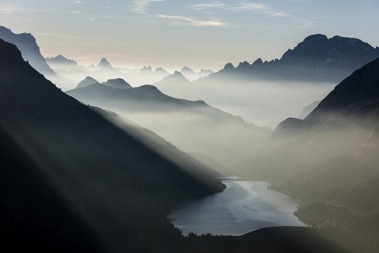Mist on peaks of Dolomites and Monte Civetta seen from Cima Belvedere at dawn, Val di Fassa, Trentino-Alto Adige