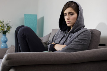 Fototapeta premium Woman feeling lonely and heart broken at home sitting on sofa