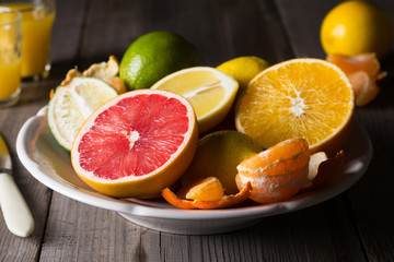 various types of citrus fruit on a dark wooden background