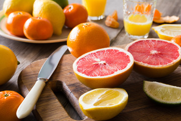 various types of citrus fruit on a wooden background
