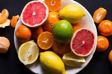 various types of citrus fruit on a dark background