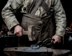 Rustic blacksmith forges item on the anvil - obrazy, fototapety, plakaty
