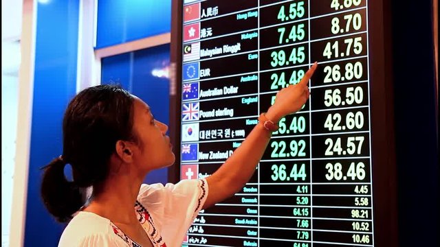 Woman watching the current rate money on board exchange office 