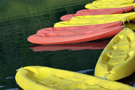 Yellow kayak and Orange kayak on water .