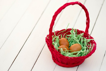 Fototapeta na wymiar Eggs in red basket with white wooden background.