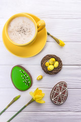 Happy holidays. Easter eggs gingerbread, cappuccino and daffodils