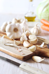 Fototapeta na wymiar Bulbs of garlic, carrots, cabbage and olive oil
