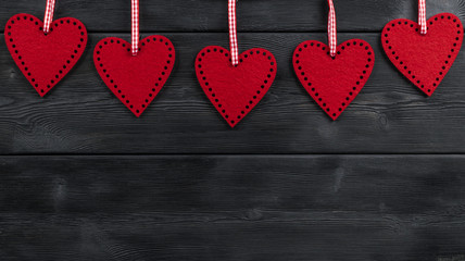 red hearts on the black rustic wooden background with woodgrain texture