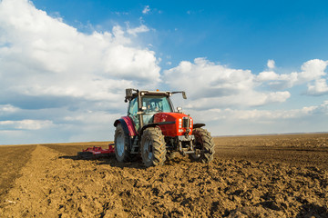 Obraz premium Farmer in tractor preparing land with seedbed cultivator as part of pre seeding activities in early spring season of agricultural works at farmlands.