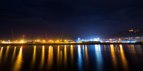Viana do Castelo Shipyard at Night, the City Lights Reflection on the River. - obrazy, fototapety, plakaty