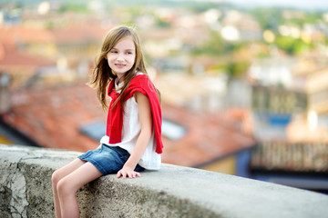 Adorable girl on warm and sunny summer day in Desenzano del Garda town in Italy