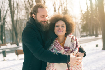 Fototapeta premium Romantic multiethnic couple in love hugging on the street