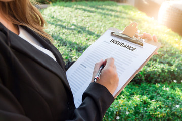 Business women in black suit sign the insurance contract