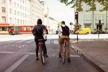 Rear view of business people riding bicycle on city street
