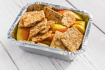 Healthy food in foil box, diet concept. Apple dessert