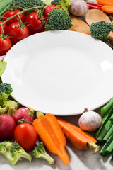 background white plate and organic vegetables, vertical