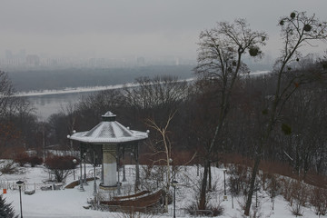 Nice winter landscape. Morning in city. Pavilion in the Park Vichnoj Slavi. Buildings are hiding in the fog on the left bank of the Dnipro. Kyiv. Ukraine