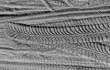 Tire tracks on sand in black and white