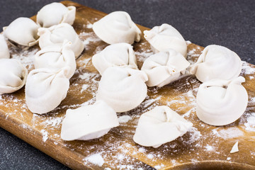 Cooked ravioli on the board with flour