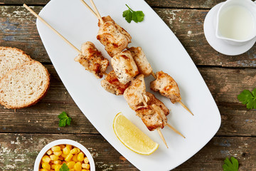 chicken kebab with a lemon and parsley on a wooden surface. Healthy food. top view