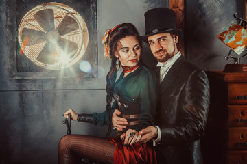 Obraz premium Pretty flirting couple dressed in vintage costumes on the dark room background.