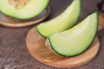 Green melon on wooden plate