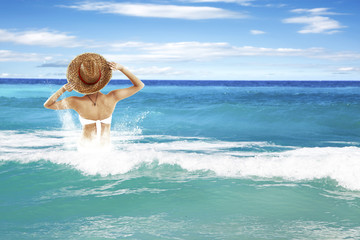 Fototapeta na wymiar waves on sea and woman in bikini 