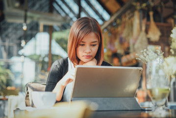 Asian woman using laptop in coffee shop