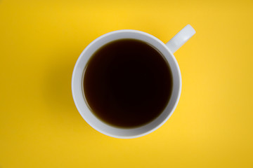 Coffee cup overhead on bright yellow background