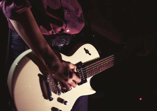 Guitarist playing electric guitar on black background