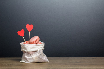 Macarons in a paper bag with red paper hearts