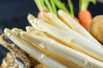 Fototapeta na wymiar Spring dinner ingredients - fresh white uncooked asparagus, carrot 